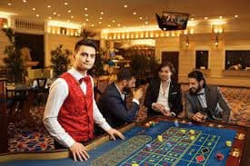 Meja Caribbean Stud Poker di ovoslot dengan dealer dan kartu yang jelas terlihat
